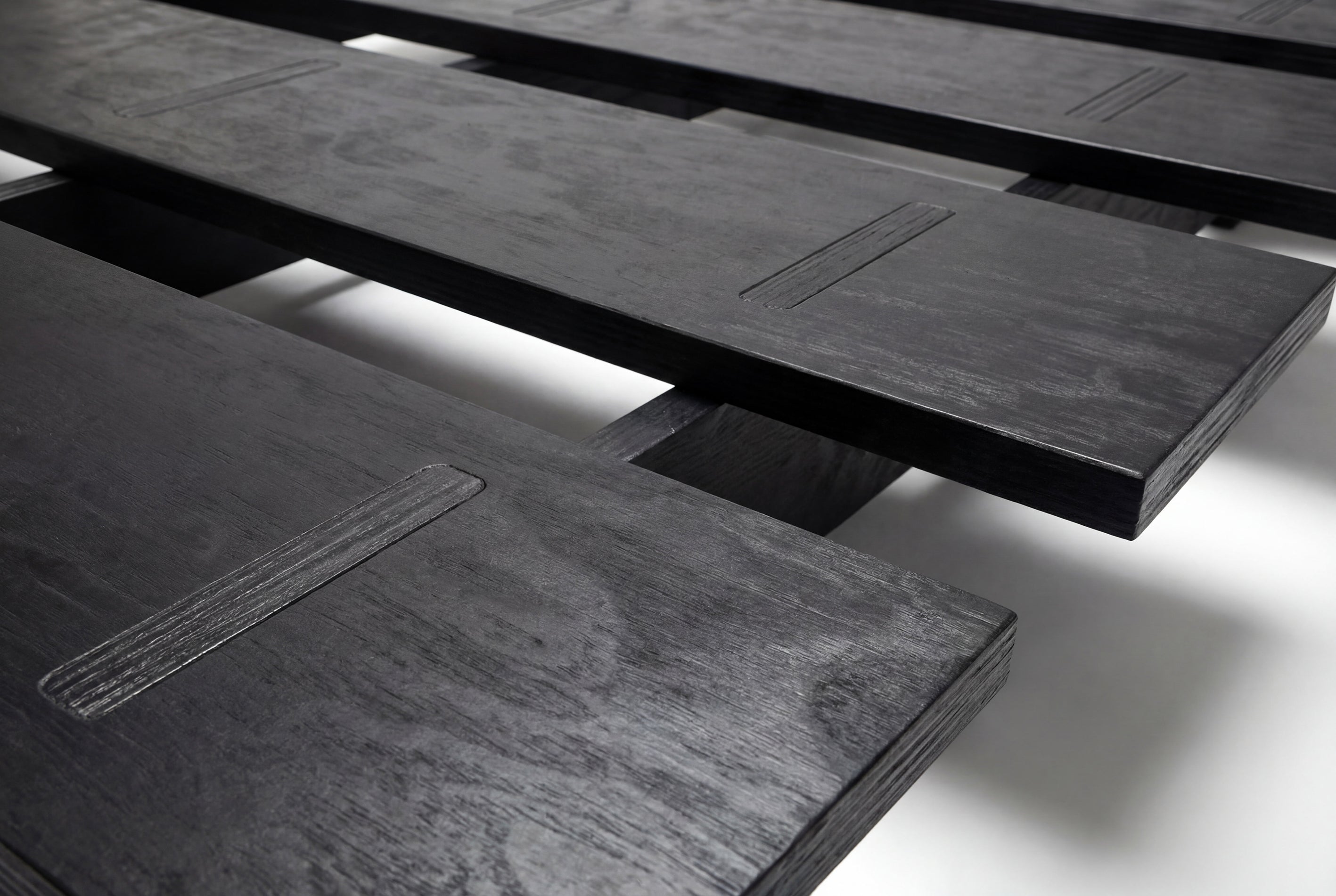 Cama Mikado, de madera y elaborado artesanalmente en España para Futon Barcelona. Montaje fácil sin tornillos, por encaje, producto ecológico. Madera negra. Imagen de producto de cerca.