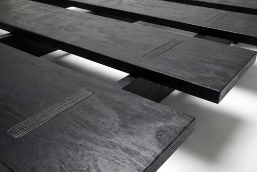 Cama Mikado, de madera y elaborado artesanalmente en España para Futon Barcelona. Montaje fácil sin tornillos, por encaje, producto ecológico. Madera negra. Imagen de producto de cerca.